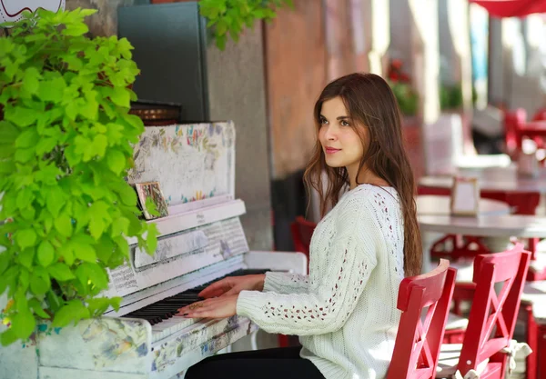 Menina sonhadora tocando em um piano velho no café de rua — Fotografia de Stock