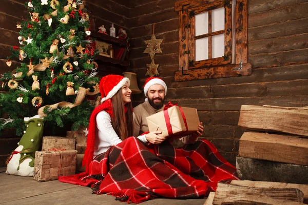 Happy Christmas couple in celebrating in the old wooden house — Stock Photo, Image