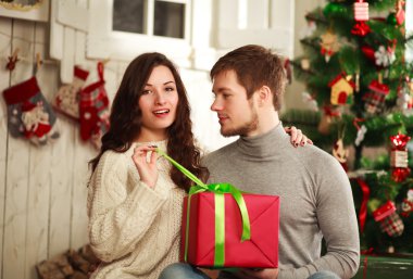 Bir arka plan üzerinde evde hediye ile mutlu çiftimiz Noel 