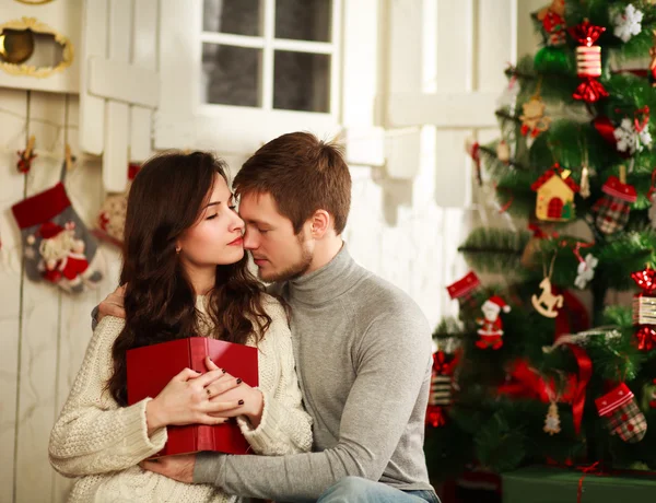 Verliebtes Paar auf einem Hintergrund aus Weihnachtsdekoration — Stockfoto