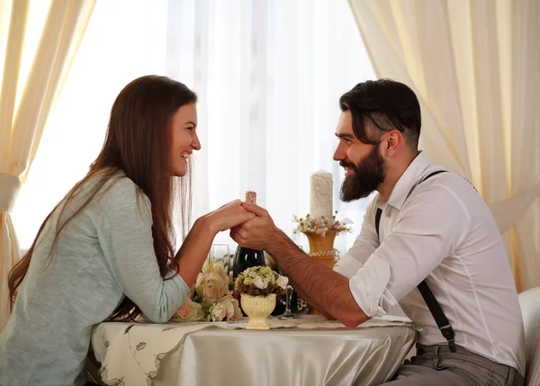 Couple in love  sitting at a table in a restaurant holding hands — Stock Photo, Image