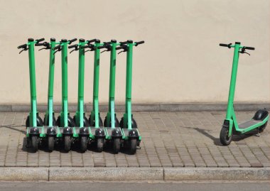 Sokakta kaldırıma park etmiş bir sürü scooter var. ...