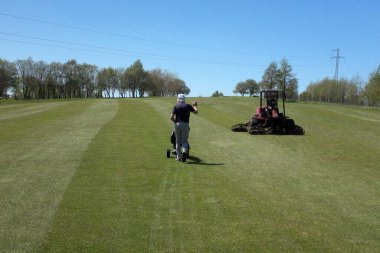 Yalnız bir golfçü golf kulübü çalışanını selamlar. ...