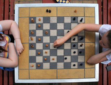 Gençler, iki kız yukarıda satranç oynuyor. ... 