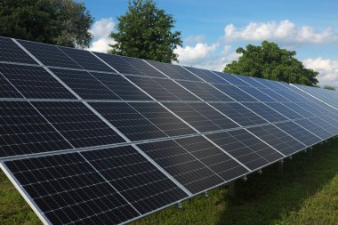 Güneş ışığının yansıması güneş fotovoltaik panellere yakın doğanın arka planına sahip çimlerin üzerine yerleştirilmiş. ...