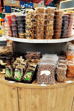 Süpermarket vitrininde çeşitli fındıklar ve kurutulmuş meyveler, perakende, market ve gıda paketleme konsepti için sağlıklı atıştırmalık seçimi.
