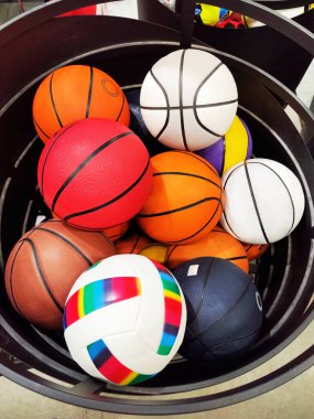 Yığınla renkli basket topu. Spor malzemeleri. Spor malzemeleri mağazası. Dikey mobil fotoğraf.
