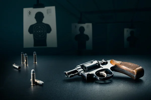 Gun on a table with bullet shells — Stock Photo, Image