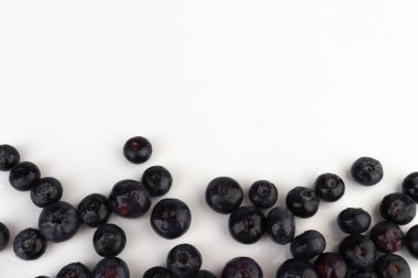 beyaz arkaplana dağılmış yabanmersinleri..