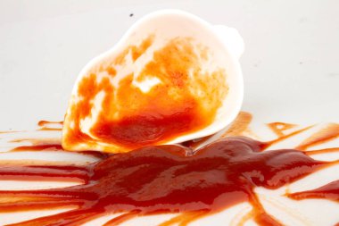 Ketçap, beyaz arka planda izole edilmiş bir fincan domatesin içinde..