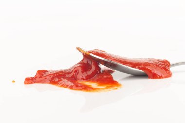 Beyaz arka plan kaşığında izole edilmiş domates ketçapı.