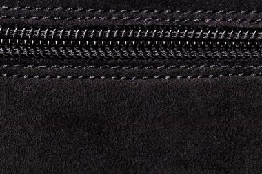 Fermuarlı arka plan dokusu. Kapalı plastik bir fermuarın siyah süet ayakkabıya iliştirildiği yüksek çözünürlüklü bir yakın çekim. Makro fotoğraf.