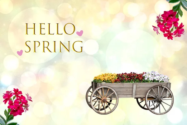 こんにちは春のカード 多くのカラフルな花と抽象的な明るい背景の上にハロー春のテキストと古い装飾的な大きな木製のカートと幸せな春やグリーティングカードのデザイン — ストック写真