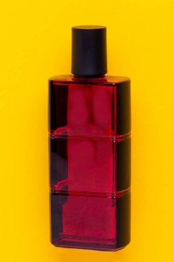 Kozmetik etiketler. Sarı arka planda kırmızı, zarif, erkek parfüm şişesinin yakın çekimi. Kendi etiketiniz için alanı kopyalayın. Makro. Reklamcılık.