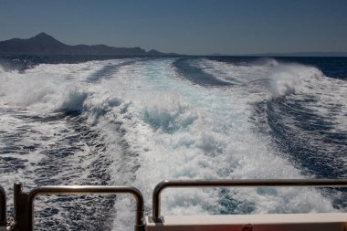 Tatil konsepti. Ege Denizi 'ndeki sürat teknesi ya da sürat teknesinin arkasında uyanık ya da deniz spreyi var. Güverteden yaklaş. Tatil, yaz, seyahat, su sporları ve aktif turizm.