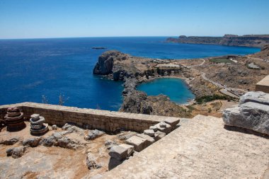 LINDOS, Yunanistan - Haziran 05, 2021. Lindos 'taki Akropolis' ten kalp şeklinde Saint Paul Körfezi 'ne rüya gibi plajlar ve kristal berrak suyla bakın..