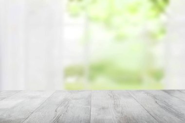 Soyut bulanık perdenin önündeki boş kırsal ahşap masa üstü doğal yeşil arka plan. Ürün görüntüleme kurgunuz için şablon. Tasarım için boşluk.