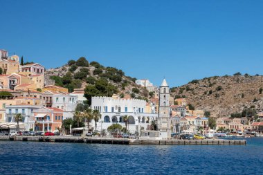 SYMI, Yunanistan - Haziran 03, 2021. Chorio ve Gialos ilçeleri ile Symi kasabası tüm Ege 'nin en güzel ve romantik limanlarından biridir. Dik yamaçlara uzanan renkli malikaneler.