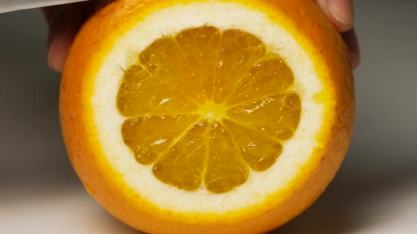 Mão cortando frutas frescas de laranja. Alimentação saudável, cozinhar e fazer dieta. — Vídeo de Stock