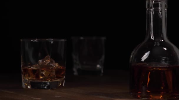 Szkło z whisky i lodem na drewnianym stole. — Wideo stockowe