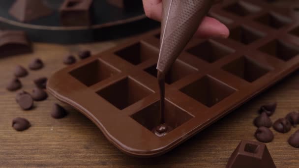 Fabricación de dulces de chocolate hechos a mano sobre fondo de madera. — Vídeo de stock