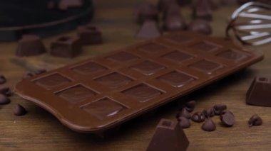 Ahşap arka planda ev yapımı koyu çikolatalar yapmak..