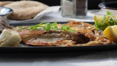 Delicious grilled sea bream fish with lemon in a seafood restaurant.