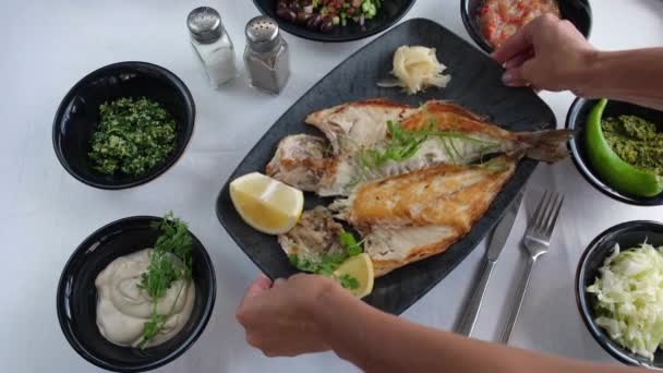 해산물 식당에서 튀긴 생선 접시를 식탁에 놓는 모습. — 비디오