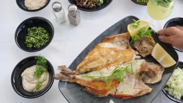 해산물 식당에서 튀긴 생선 접시를 식탁에 놓는 모습. — 비디오