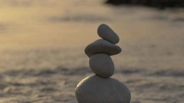 Vyváženost kamenů na pozadí moře na západě slunce. — Stock video