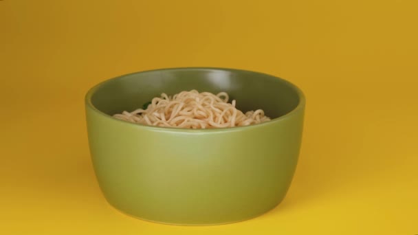 Fideos instantáneos en tazón sobre fondo amarillo. — Vídeo de stock