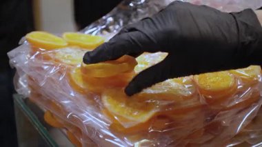 Plastik ambalajda dilimlenmiş kuru portakallar, yiyecek üretim süreci.