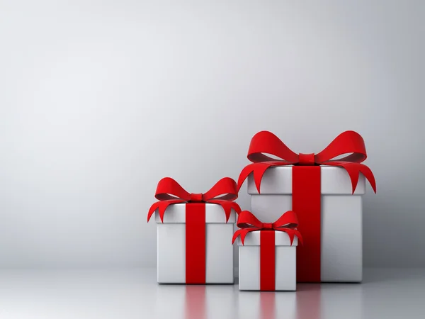 Cajas de regalo con lazo de cinta roja y pared blanca vacía — Foto de Stock