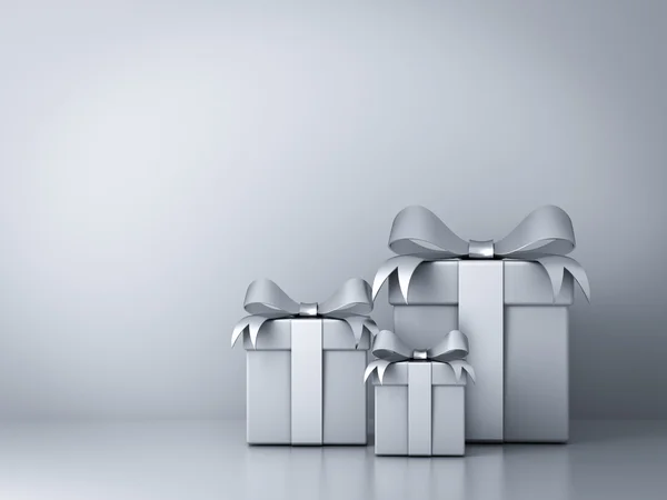 Geschenkboxen mit silberner Schleife und leeren weißen Wandhintergrund — Stockfoto