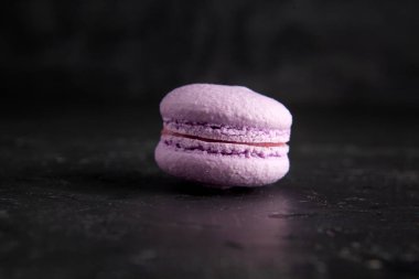 colored fresh macarons in studio on black background