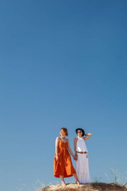 Yazın çölde sıcak kumda yürüyen iki kadın.