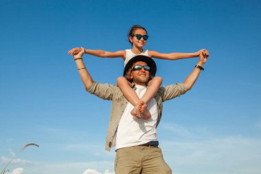 Bir adam yazın çölde bir çocuğu omuzlarında taşır.