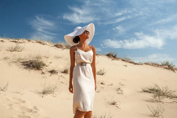 夏の砂漠の砂の上をサングラス姿の女性が歩く ロイヤリティフリーのストック画像