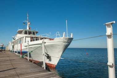 Yazın denizde, rıhtımda beyaz bir tekne.