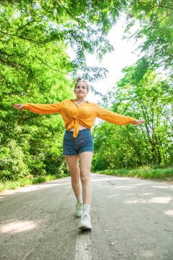Yazın yolda şortlu genç bir kadın.