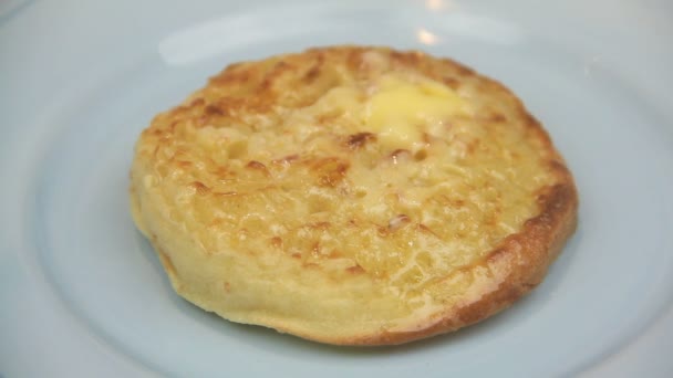 Hete Engelse crumpet met boter wordt gesneden in de helft met een mes — Stockvideo
