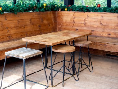 Boş ahşap masa ve içi Noel süsü süslemeli ahşap sandalyeler..