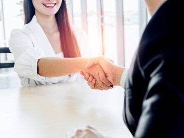 İş adamları ofiste başarılı bir şekilde el sıkışıyor. Genç bayan aday takım elbiseli işadamıyla tokalaşıyor, iş görüşmesinden sonra işverenle. Başarı takım çalışması, ortaklık ve tokalaşma.