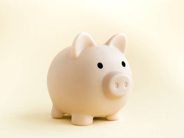 Şirin kumbara, yumuşak bej arka planda izole edilmiş pembe renk. Tasarruf, Yatırım ve finans kavramı.