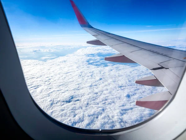 雲の上 飛行機の翼を持つ素晴らしい空 飛行機の窓からの眺め ふわふわの雲と青空を背景にした美しい雲景 — ストック写真