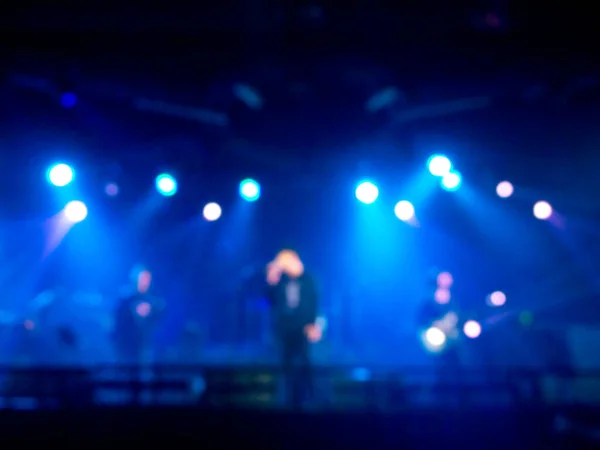 黒を基調とした青のライトを持つミュージシャンとステージ上で演奏する青い岩のコンサート ロックバンドコンサートでのブリュリー音楽パフォーマンス — ストック写真