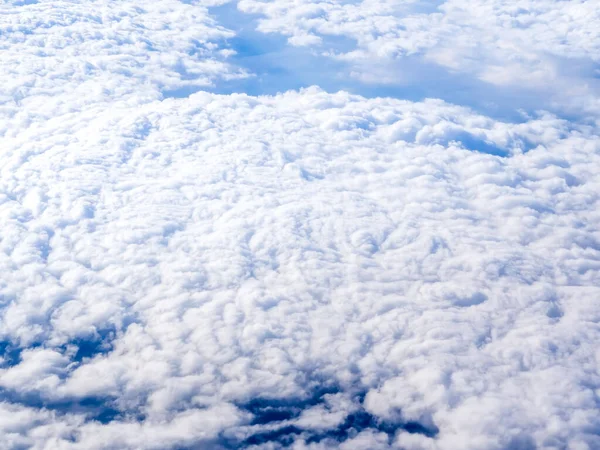 在云彩之上 从飞机窗上俯瞰着迷人的天空 多云蓝天背景的美丽云彩风景 图库图片