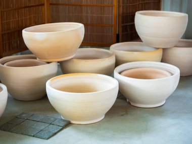 Beton zemine yerleştirilmiş bir sürü boş seramik saksı. Boş seramik ekici arkaplanı.