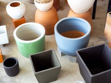 Beton zemine dizilmiş çeşitli renkli seramik saksılar. Boş geometrik seramik ekici arkaplanı.