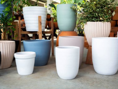 Beton zemine dizilmiş çeşitli renkli seramik saksılar. Boş geometrik seramik ekici arkaplanı.